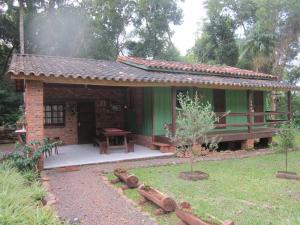 a small green house with a table in a yard at Pousada Vida Artesanal in Pedra