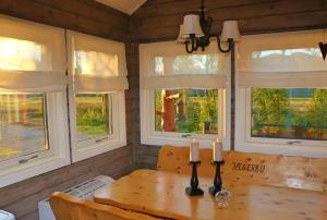 a dining room with a wooden table and windows at Cabin by the river in Storslett