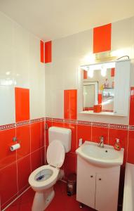 un bagno rosso e bianco con servizi igienici e lavandino di Stephanie Apartment a Braşov