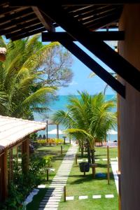 a view of a resort with palm trees and the ocean at Ravenala Hotel in Arraial d'Ajuda