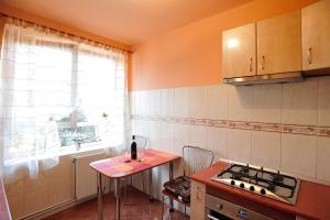 una cucina con piano cottura, tavolo e finestra di Stephanie Apartment a Braşov