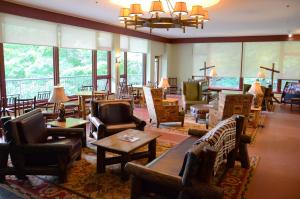 eine Hotellobby mit Stühlen, Tischen und Fenstern in der Unterkunft Overlook Lodge and Stone Cottages at Bear Mountain in Highland Falls