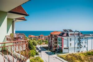 a balcony with a view of the ocean and buildings at Family Hotel Amore in Byala