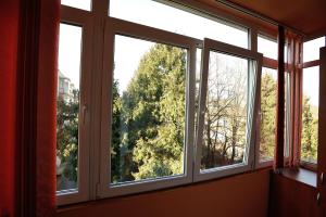three windows in a room with trees at Stephanie Apartment in Braşov