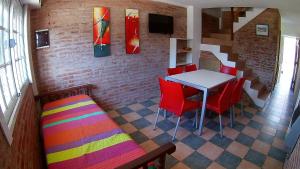 a dining room with a table and red chairs at Alquileres Relax11sanclemente in San Clemente del Tuyú