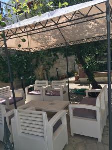 un gruppo di sedie bianche e un tavolo sotto una tenda di Arte & Mare a Patti
