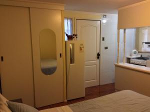 a kitchen with a white refrigerator in a room at Hostal Brisas del Sur in Temuco