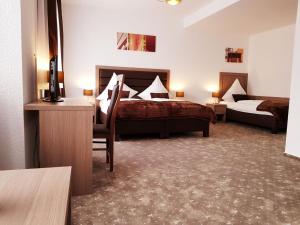 Pokój hotelowy z 2 łóżkami i biurkiem w obiekcie Hotel Dormir w mieście Moers