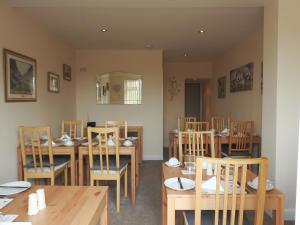 a dining room with wooden tables and chairs at Cherish End Guest House in Dunstable