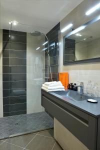 La salle de bains est pourvue d'un lavabo et d'une douche. dans l'établissement Hôtel d'Argouges, à Bayeux