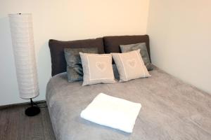 sypialnia z łóżkiem z poduszkami i lampą w obiekcie Apartament Bartolomeo w Toruniu