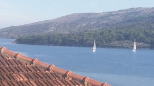 deux voiliers sur un grand lac avec une montagne dans l'établissement Villa Marija, à Marina