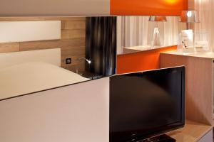 TV a/nebo společenská místnost v ubytování Hotel Le Colombier Suites
