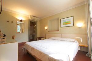 a bedroom with a white bed and a bathroom at La Bussola Da Gino in Quarrata