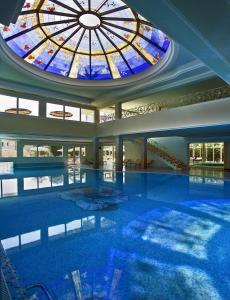 a large swimming pool with a stained glass ceiling at Palace Hotel Meggiorato in Abano Terme