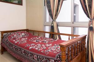 1 dormitorio con cama roja y ventana en Salta,Departamento Para Visitar la Virgen Del Cerro o Viaje De Placer en Salta
