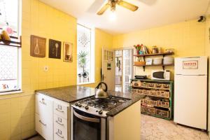 a yellow kitchen with a stove and a refrigerator at Discovery Hostel in Rio de Janeiro