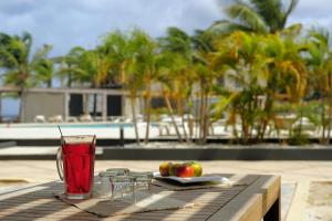 a table with a drink and some fruit on it at Eden Beach Resort - Bonaire in Kralendijk