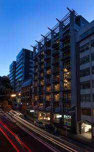 een hoog gebouw in een stadsstraat 's nachts bij Quest Atrium Serviced Apartments in Wellington