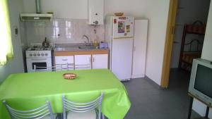 a kitchen with a green table and a white refrigerator at Departamento Carlos Paz in Villa Carlos Paz