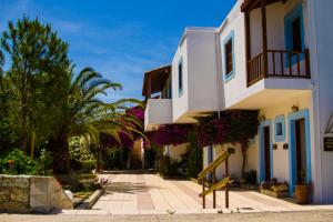 uma casa branca com plantas ao lado dela em Spiros-Soula Family Hotel & Apartments em Agia Pelagia