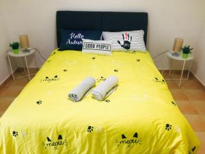 a yellow bed with two bat pillows on it at Luxury Villa @ A'F Resort in Melaka +20 photos