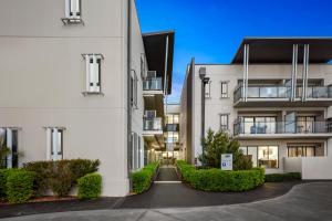 an alley between two white buildings with bushes at Quest Singleton in Singleton