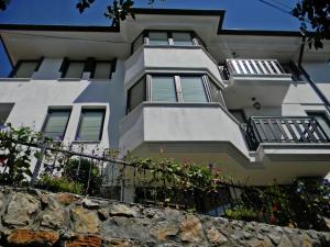 un edificio blanco con balcones y una pared de piedra en Villa Kale, en Ohrid