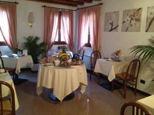 a dining room with two tables and two windows at Ca'Nova Alloggi in Campalto