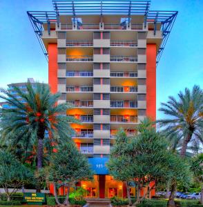 un grand bâtiment avec des palmiers devant lui dans l'établissement The Mutiny Luxury Suites Hotel, à Miami