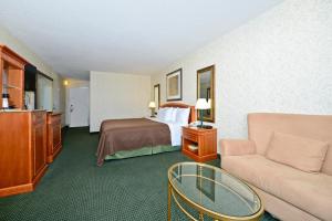 a hotel room with a bed and a couch at Americas Best Value Inn - Baltimore in Baltimore