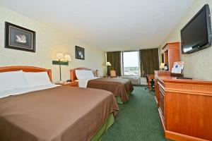 a hotel room with two beds and a flat screen tv at Americas Best Value Inn - Baltimore in Baltimore