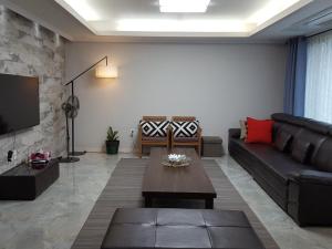 a living room with a couch and a coffee table at Oh Happy Day Jeju in Jeju