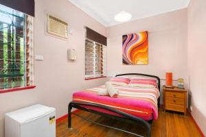 a bed in a room with a painting on the wall at Dreamtime Travellers Rest in Cairns