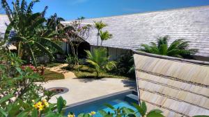 a garden with a swimming pool next to a house at Villa Kalachuchi V.K in Puerto Princesa City