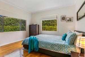 a bedroom with a bed and two windows at Bonnie Blairgowrie in Blairgowrie