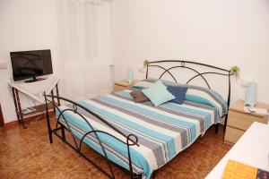 1 dormitorio con 1 cama y TV en una habitación en Affittacamere Fiorella, en Riomaggiore