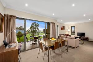 a living room with a table and a dining room at Quest Singleton in Singleton