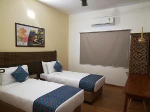 a hotel room with two beds and a projection screen at Hotel Beebiz Guindy in Chennai