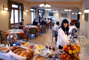 um grupo de pessoas sentadas à mesa com comida em Ametiszt Hotel Harkány em Harkány