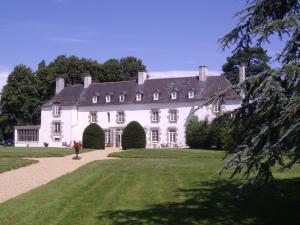 una gran casa blanca con un gran patio en Les Roulottes de la Baronnie en Saint-Malo