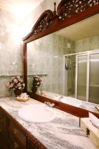 a bathroom with a sink and a large mirror at Dallas Residence Suites in Varna City