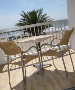 a table and chairs on a balcony with the beach at Hôtel Restaurant Splendid Camargue in Le Grau-du-Roi
