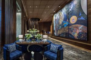 a lobby with a table and chairs and a large painting at 137 Pillars Residences Bangkok in Bangkok