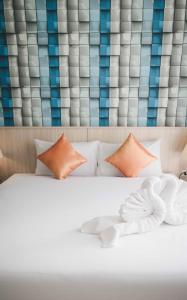 a white bed with orange pillows in a room at The Wings Boutique Hotels Krabi Ko Lanta in Ko Lanta