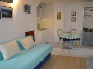 a bedroom with a bed and a table and a kitchen at Studio Apartments Kuljiš in Vis