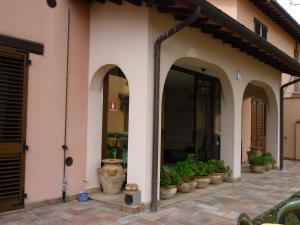 a building with arches and potted plants on a patio at Tadinum Romana in Gualdo Tadino