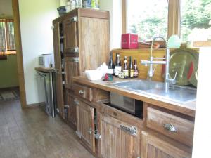 a kitchen with wooden cabinets and a sink at home in the Flemish Ardennes between the meadows in Sint-Kornelis-Horebeke