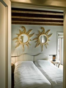 ヴェローナにあるSuite Ponte Pietraのベッドルームのベッドの上に鏡が2つあります。