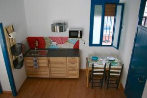 una pequeña cocina con mesa y sillas en una habitación en El Taller del Abuelo, en Córdoba